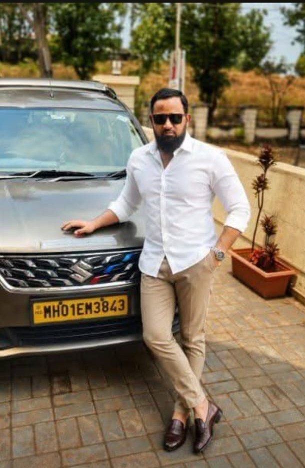 Amin, private chauffeur in Mumbai, standing beside his car
